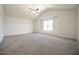 Spacious main bedroom with vaulted ceilings, ceiling fan, large window and neutral carpet at 223 Johnson Ridge Way, Four Oaks, NC 27524
