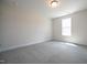 A bedroom features soft carpet flooring and ample natural light from the window at 236 Johnson Ridge Way, Four Oaks, NC 27524