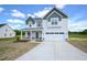 Charming two-story home with a two-car garage, concrete driveway, landscaped front yard, and covered front porch at 236 Johnson Ridge Way, Four Oaks, NC 27524