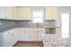 Bright kitchen featuring stainless sink, granite counters and white cabinets at 236 Johnson Ridge Way, Four Oaks, NC 27524
