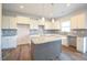 Bright kitchen featuring granite counters, stainless sink, kitchen island and white cabinets at 236 Johnson Ridge Way, Four Oaks, NC 27524