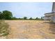 A large side yard with straw and trees, with a partial view of the side of a house at 236 Johnson Ridge Way, Four Oaks, NC 27524