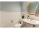 Charming powder room with decorative mirror, pedestal sink, and paneled walls at 2407 Cattail Pond Dr, Zebulon, NC 27597