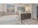 A luxurious bathroom featuring a soaking tub, double vanity, and decorative mosaic tiles at 2407 Cattail Pond Dr, Zebulon, NC 27597