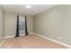 A bedroom with neutral walls, carpeting, and a single window with blue curtains at 2407 Cattail Pond Dr, Zebulon, NC 27597