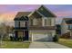 Charming two-story home featuring a stone facade, attached two-car garage, and well-maintained lawn at 2407 Cattail Pond Dr, Zebulon, NC 27597