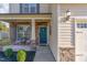 Inviting front porch with stone accents, teal door, and seating area at 2407 Cattail Pond Dr, Zebulon, NC 27597