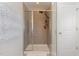 A modern shower with gray tile, a rainfall showerhead, and sleek glass doors at 2407 Cattail Pond Dr, Zebulon, NC 27597