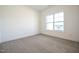 Spacious bedroom with neutral carpet, bright lighting, and a large window offering ample natural light at 247 Johnson Ridge Way, Four Oaks, NC 27524
