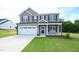 Charming two-story home with a covered front porch, two-car garage, and a well-manicured front lawn at 247 Johnson Ridge Way, Four Oaks, NC 27524