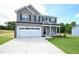 Charming two-story home with a covered front porch, two-car garage, and a well-manicured front lawn at 247 Johnson Ridge Way, Four Oaks, NC 27524