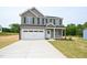 Charming two-story home featuring a gray exterior, two-car garage, and well-manicured lawn at 247 Johnson Ridge Way, Four Oaks, NC 27524