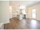 Modern kitchen featuring a central island, stylish pendant lighting, white cabinets, and vinyl flooring, blending style and functionality at 247 Johnson Ridge Way, Four Oaks, NC 27524