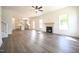 Bright, open living area flows into a modern kitchen featuring a fireplace, ceiling fan, and large windows at 247 Johnson Ridge Way, Four Oaks, NC 27524