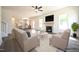 Open living area features a fireplace, ceiling fan, large windows, and flows into a modern kitchen, great for entertaining at 247 Johnson Ridge Way, Four Oaks, NC 27524