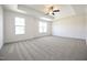 Spacious bedroom with tray ceiling, ceiling fan and large windows at 247 Johnson Ridge Way, Four Oaks, NC 27524