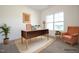 Bright office space features a large window, modern desk, and cozy seating area, perfect for a productive work environment at 247 Johnson Ridge Way, Four Oaks, NC 27524