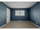 Blue bedroom with carpet flooring and a window at 2522 Hickory Ave, Burlington, NC 27215