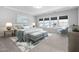 Main bedroom with a king-size bed, two ottomans, and window at 2923 Heirloom Way, Apex, NC 27502