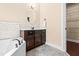 Well-appointed bathroom featuring a soaking tub, dark wood cabinetry, and walk-in closet at 347 Country Mill Way, Fuquay Varina, NC 27526