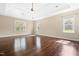 Bright bedroom with hardwood floors, tray ceilings, and large windows overlooking wooded area at 347 Country Mill Way, Fuquay Varina, NC 27526
