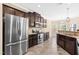 Spacious kitchen with stainless steel appliances, granite countertops, dark wood cabinetry, and tiled floors at 347 Country Mill Way, Fuquay Varina, NC 27526