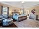 Elegant primary bedroom featuring hardwood floors, tray ceiling, and relaxing sitting area at 347 Country Mill Way, Fuquay Varina, NC 27526