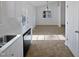 White kitchen with stainless steel dishwasher and view into dining area at 4532 Hidden Hollow Ln, Knightdale, NC 27545