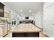 Modern kitchen with island, granite countertops, and open view to living area at 53 Albereto Dr, Clayton, NC 27527