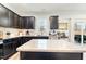 Modern kitchen with dark cabinetry, granite island, and stainless steel appliances at 53 Albereto Dr, Clayton, NC 27527