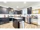 Modern kitchen with dark cabinetry, granite island, and stainless steel appliances at 53 Albereto Dr, Clayton, NC 27527