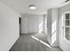 Bright bedroom with grey carpet and two windows at 5340 Fayetteville Rd, Durham, NC 27713