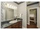 Bathroom with marble vanity, decorative wallpaper, and mirror at 5891 Baker Ln, Rocky Mount, NC 27803
