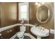 Powder room with pedestal sink, decorative mirror, and toilet at 5891 Baker Ln, Rocky Mount, NC 27803