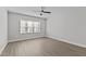 A bright bedroom featuring a large window with wood-look flooring and ceiling fan at 608 Marshskip Way, Rolesville, NC 27587