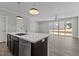 Open-concept living room with kitchen island, dining area, and sliding doors to the backyard at 608 Marshskip Way, Rolesville, NC 27587