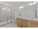 Modern bathroom with a glass-enclosed shower, double vanity, and neutral color palette at 610 Marshskip Way, Rolesville, NC 27587