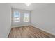 Well-lit bedroom featuring two windows, natural light, and sleek wood-look flooring at 610 Marshskip Way, Rolesville, NC 27587
