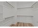 Organized walk-in closet with multiple rods for ample hanging storage, and wood-look flooring at 610 Marshskip Way, Rolesville, NC 27587