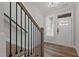A modern entryway with wood stairs and sleek iron railing, offering a stylish and inviting welcome into the home at 610 Marshskip Way, Rolesville, NC 27587