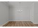 Open living room with hardwood floors, modern lighting fixture, and neutral paint at 610 Marshskip Way, Rolesville, NC 27587