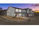 Modern townhome exterior featuring gray siding, white garage doors, and manicured landscaping at sunset at 612 Marshskip Way, Rolesville, NC 27587