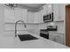 Modern kitchen with white cabinets, quartz countertops, and a large sink at 612 Marshskip Way, Rolesville, NC 27587