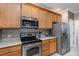 Modern kitchen with stainless steel appliances and wood cabinets at 617 Eyam Hall Ln, Apex, NC 27502