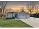 Beautiful single-story home with three-car garage, manicured lawn, and attractive gray siding in a natural setting at 620 Rollins Mill Rd, Holly Springs, NC 27540