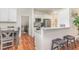 Well-lit kitchen with stainless steel appliances, marble countertops, breakfast bar, and wood flooring at 620 Rollins Mill Rd, Holly Springs, NC 27540