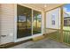 Sliding glass door opens to a screened porch with a wooden step and concrete flooring at 82 Gin Branch Rd, Wendell, NC 27591