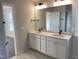 Bathroom with double vanity, modern fixtures, and a large mirror at 82 Gin Branch Rd, Wendell, NC 27591