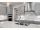 Modern kitchen with gray cabinets, white quartz countertops, and a stainless steel range hood at 82 Gin Branch Rd, Wendell, NC 27591