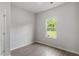 A bedroom with a window providing natural light, neutral walls, and wood flooring at 910 Rhino Bnd, Oxford, NC 27565